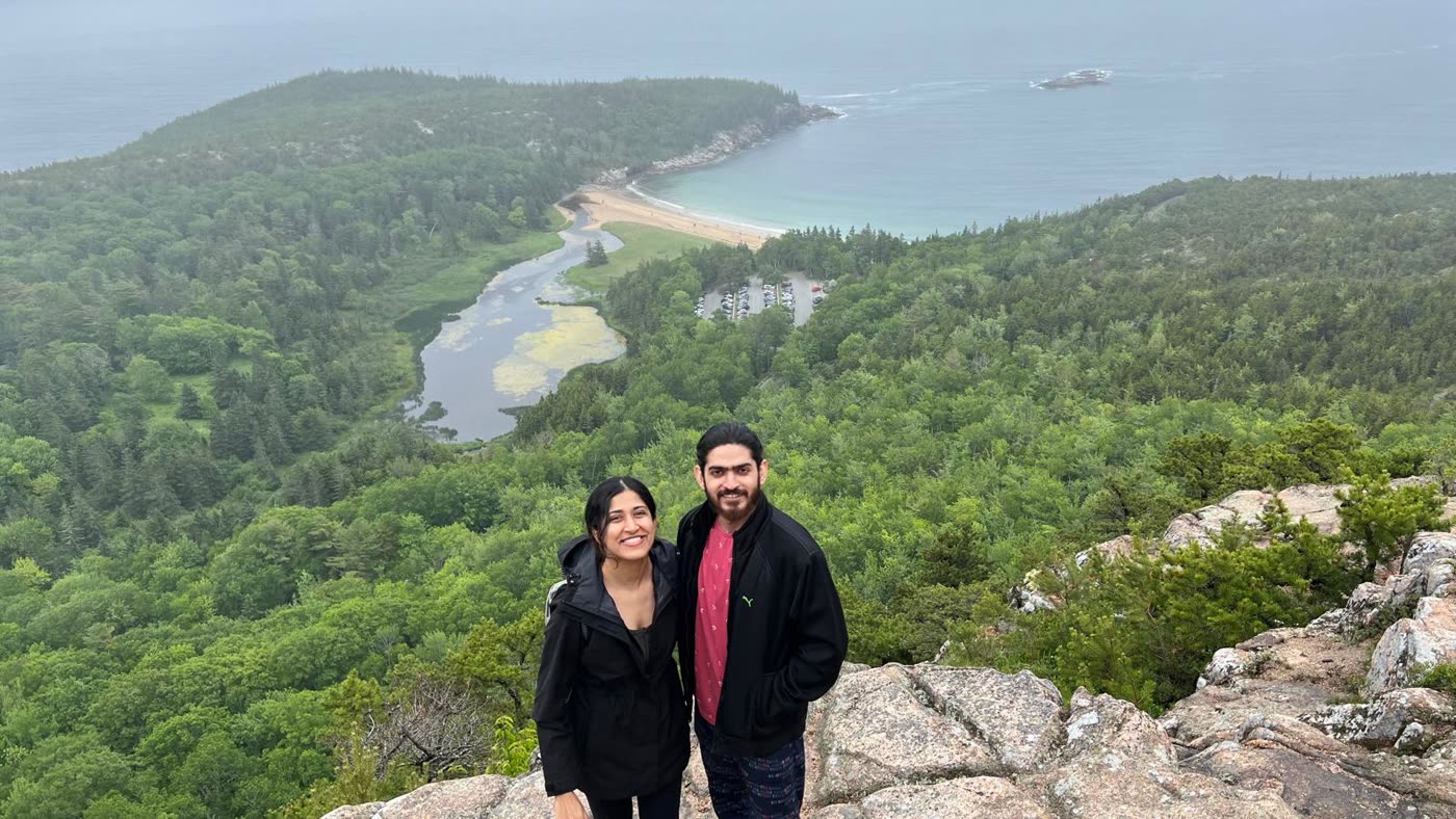 Abirami and Prateek on a hilltop above the bay